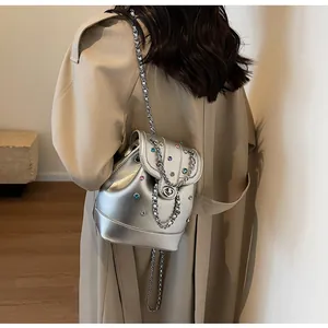 Close-up of silver metallic Y2K backpack with colorful rhinestones and metal chain