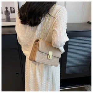 Détail du sac matelassé beige avec fermoir doré et bandoulière en chaîne chic
