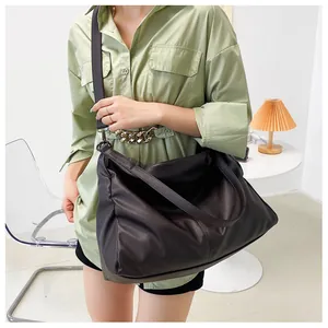 Detalle del bolso tote marrón oscuro de cuero sintético suave con correa de hombro ancha
