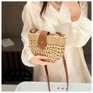 Detailed texture of straw weave shoulder bag with brown leather flap and metal clasp