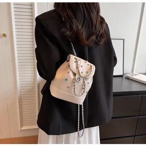 Detail of cream mini backpack with colorful rhinestones and silver chain strap