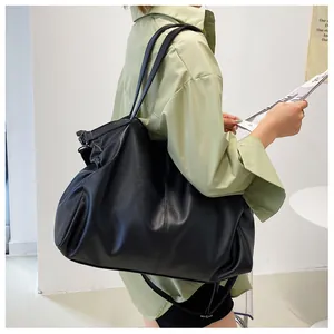 Detalle de cerca de la textura de cuero PU negro suave en el bolso tote grande para mujer