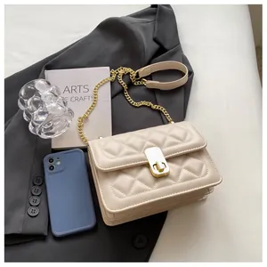 Détail de la texture matelassée beige et du fermoir doré de ce sac bandoulière
