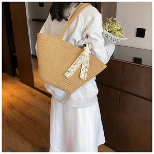 Detail of a large straw tote bag with elegant white lace ribbon in a lifestyle setting