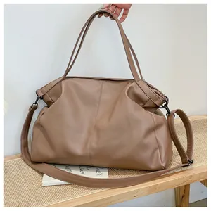 Detalle del bolso tote de cuero sintético marrón café con patrón de litchi y herrajes negros
