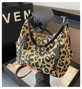 Macro shot of leopard print tote bag with multiple zip pockets and black leather trim