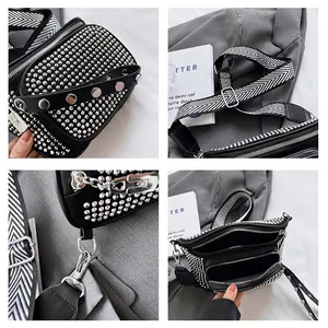 Détails des rivets argentés et de la large bandoulière à chevrons sur le sac noir