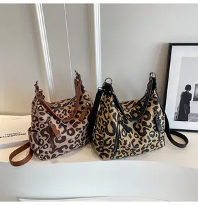 Detail of two leopard print tote bags in brown and yellow with decorative front zippers