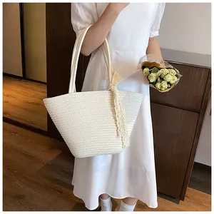 Close-up of cream woven tote bag with lace bow detail and straw texture for beach vacations
