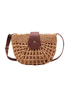 Hollow straw shoulder bag with brown leather flap and adjustable strap for summer travel