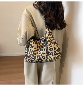 Detail shot of leopard print canvas tote bag with side zippers and black shoulder strap
