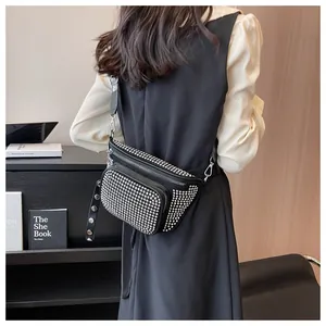 Détail d'un sac banane noir clouté avec large bandoulière porté par un mannequin