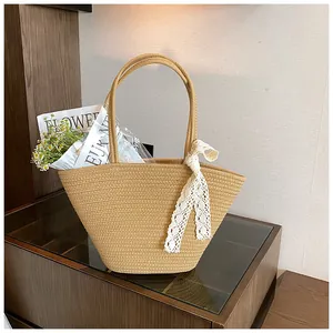 Close-up of handwoven straw tote with white crochet lace ribbon and twin handles