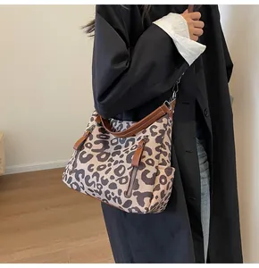Close-up of leopard print tote bag with brown leather handles and side pocket detail