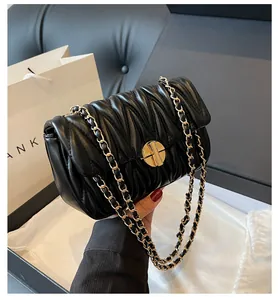 Detailansicht der schwarzen gesteppten Ledertasche mit Goldverschluss und Verpackung