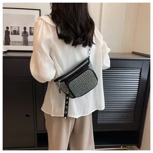 Détail du sac bandoulière noir avec strass colorés et bandoulière ornée de clous