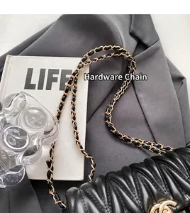 Detail einer schwarzen Stepptasche aus Leder mit eleganter goldener Metallkette