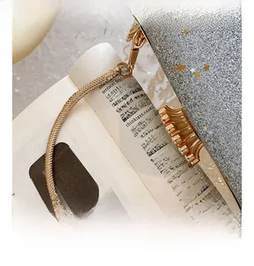 Detail of silver evening bag with gold crown buckle and sleek snake chain handle