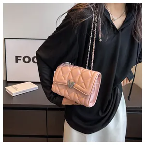 Vue détaillée du sac rose matelassé avec boucle en cœur et bandoulière en chaîne