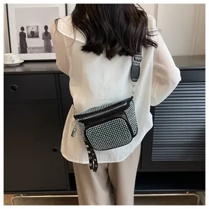 Détail d'un sac banane noir en strass avec une large bandoulière motif zèbre