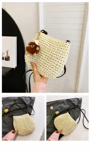 Detail van geweven rieten tas met lederen riem en een bruine pluche monster hanger