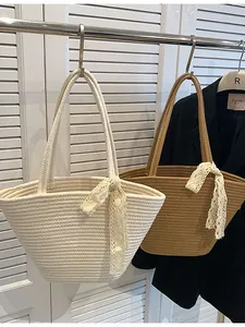 Handwoven straw beach bags in beige and brown colors with decorative lace handles