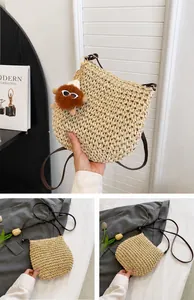 Detailoverzicht van een beige geweven stro-strandtas met een schattige hanger en bruine riem