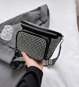 Détail d'un sac bandoulière noir avec strass colorés et large sangle géométrique