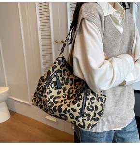 Detail of leopard print tote bag with metal zippers and detachable black strap