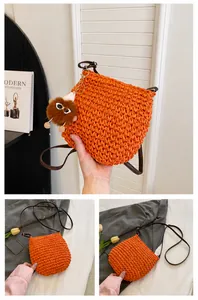 Macro-opname van de oranje stro tas met geweven textuur en pluche beer hanger