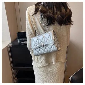 Détail du sac argenté matelassé avec fermoir coeur en métal et bandoulière chaîne