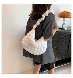 Detail van witte gewatteerde cloud bag met geplooide schouderband en nylon textuur