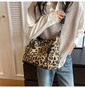 Detail of leopard print tote bag showing black metal zippers and side pocket texture