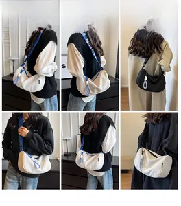 Detail of crescent hobo bag featuring wide strap with FASHION logo and blue ring charm