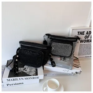 Détail de sacs banane en strass noirs et argentés sur fond de livres d'art chic