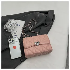 Détail du sac matelassé rose avec boucle en cœur argentée et surpiqûres en losange