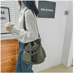 Detailweergave van grote groene nylon bucket bag met trekkoord en verstelbare riem