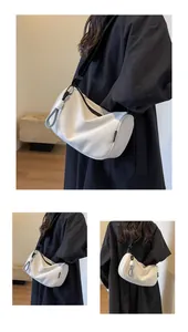 Detailed macro view of white crescent bag with black adjustable strap and knot detail