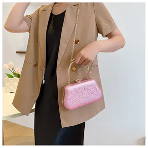 Detailed close-up of pink sequined evening clutch bag with gold handle and chain strap