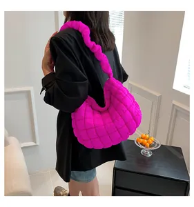Detail van roze gewatteerde wolktas met stijlvol scrunchie handvat gedragen door model
