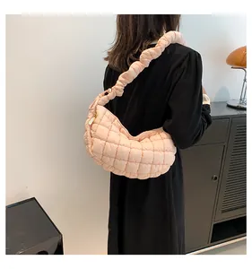 Close-up of pink quilted puffer shoulder bag with a stylish pleated cloud handle design