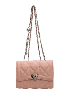 Sac bandoulière matelassé rose avec fermoir cœur et chaîne argentée sur fond blanc