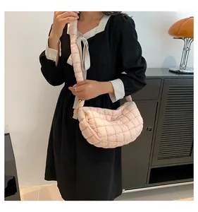 Detail of light pink quilted nylon puffer bag with matching padded shoulder strap