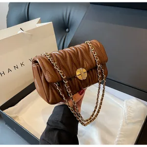Detailsicht der karamellfarbenen Steppledertasche mit goldener Schnalle in Geschenkbox