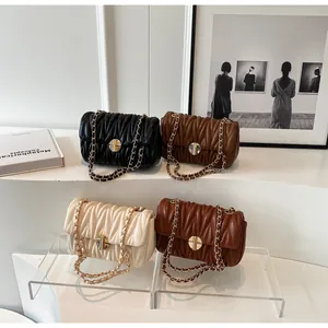 Detailansicht der Faltenleder-Handtaschen mit goldenen Drehschlössern und Ketten