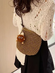 Bruine handgeweven stro schoudertas met schattige pompon hanger en leren riem