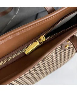 Close-up of golden zipper hardware and houndstooth fabric on the large tote bag