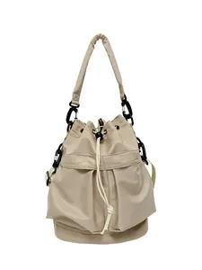 Beige nylon hobo tas met trekkoord, voorzakken en een brede schouderriem