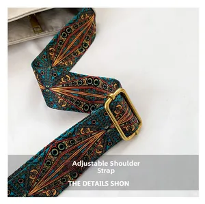 Detail of adjustable woven shoulder strap with ethnic geometric patterns and gold buckle