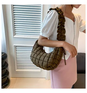 Detail van olijfgroene gewatteerde hobo-tas met ruisjes schouderband gedragen door model